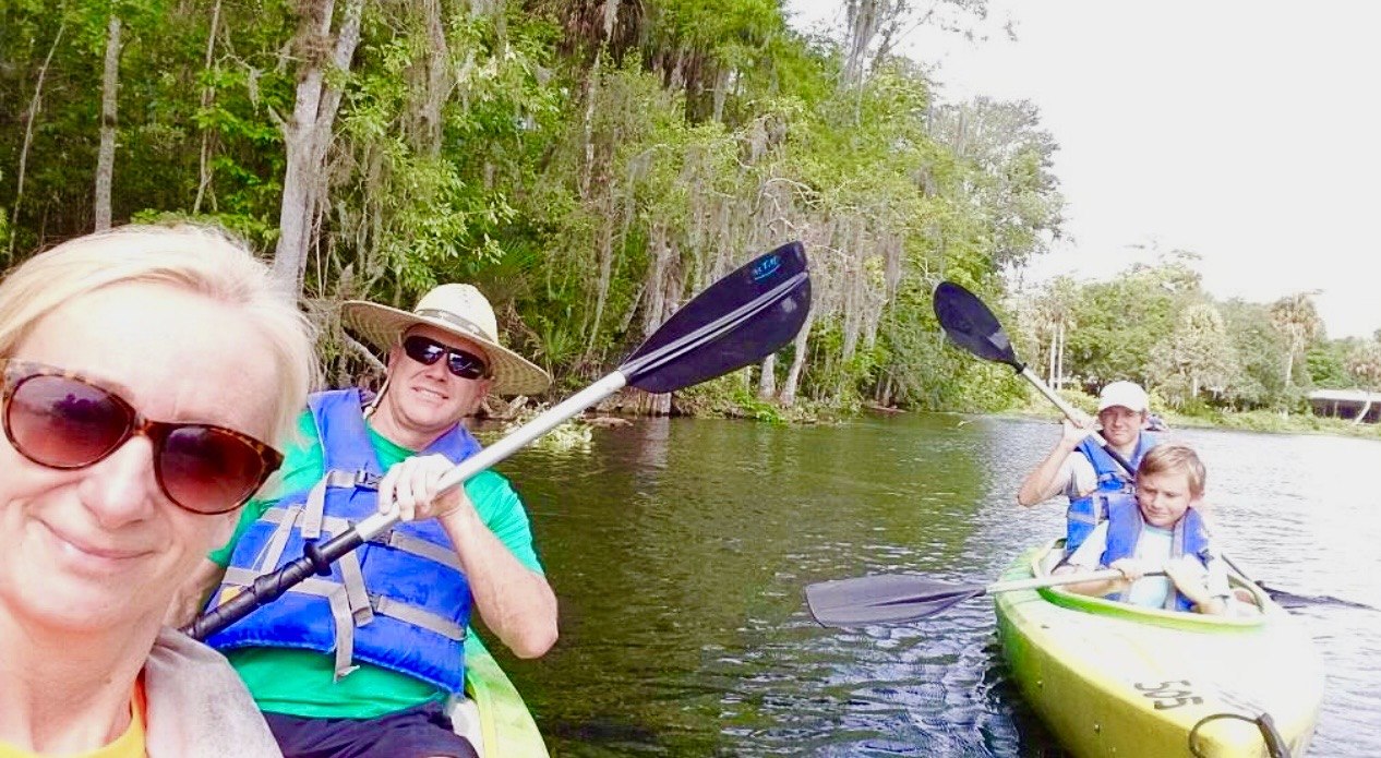 Henrietta Threatt kayaking with family on a tree-lined river